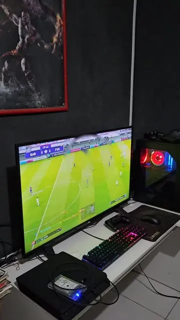 PC gamer com teclado RGB e monitor rodando EA FC